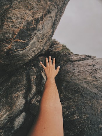 Person Trying to Reach Rock