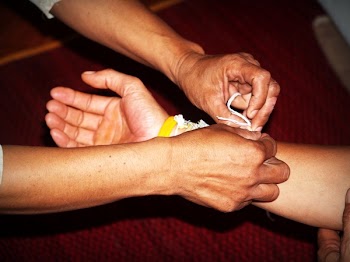 Person Tying Bracelet