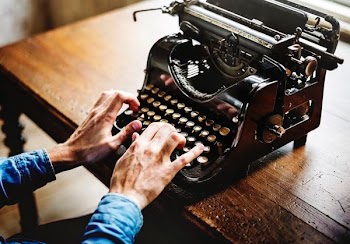 person typing on black typewriter
