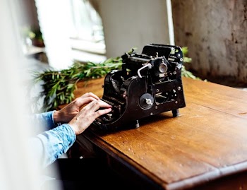 person typing typewriter on table