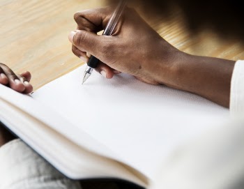 Person Uses Pen on Book