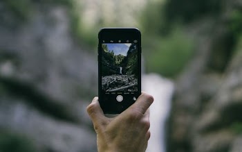 person using black smartphone during daytime