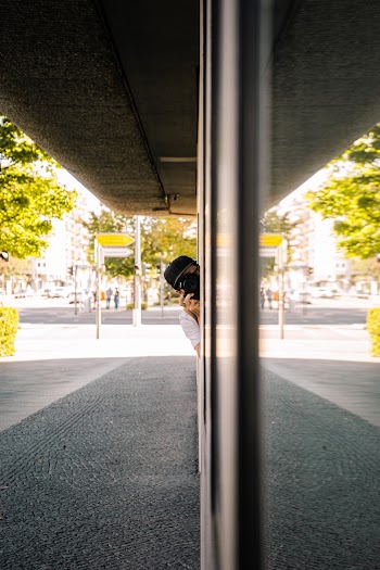 Person Using Camera Peeking Behind Wall