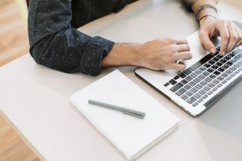 Person Using Laptop on White Surface