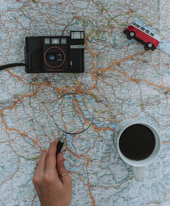 Person Using Magnifying Glass On A Map