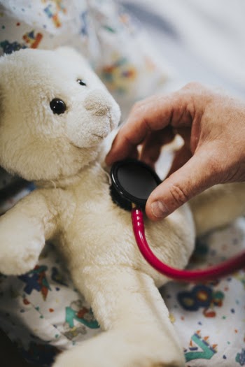 Person Using Stethoscope On Bear Plush Toy