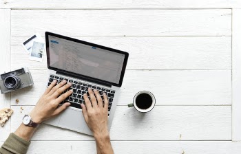 Person Using Tablet Computer Beside Mug and Camera