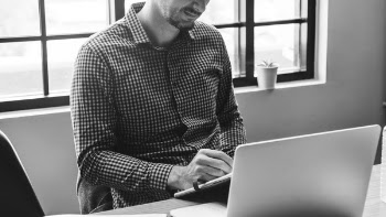 Person Using Tablet Sitting on Table