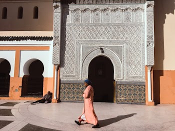 Person Walking Beside Mosque