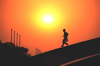 Person Walking Down Road during Golden Hour