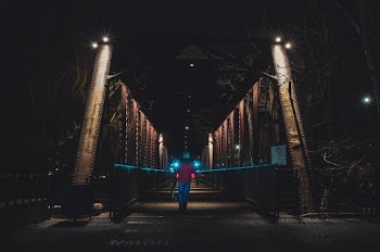 Person Walking in Bridge during Nighttime