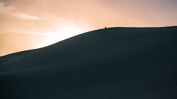 person walking in dune sand