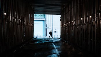 person walking in front of tunnel