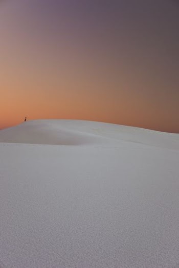 person walking in the desert dunes
