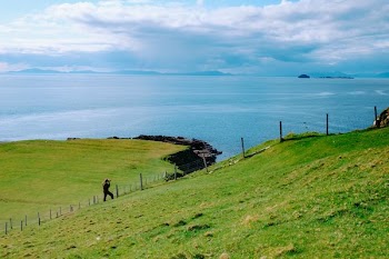 person walking near fence on hill