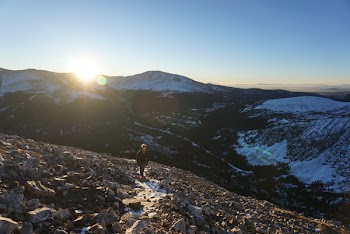 Person Walking on Mountain Covered in Stones