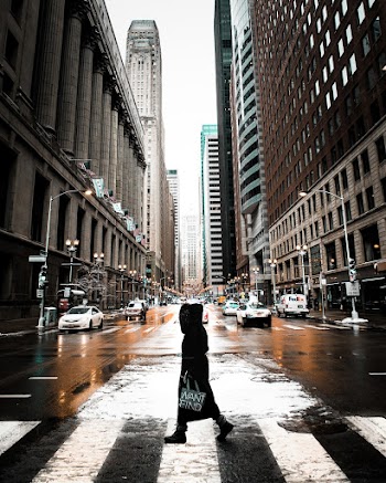 Person Walking On Pedestrian Lane Between Buildings