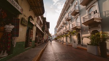 Person Walking on Road Beside Apartment