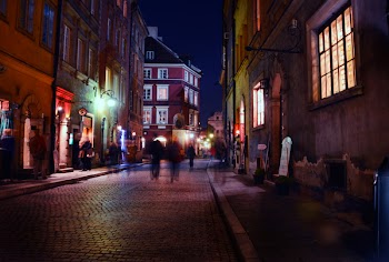 Person Walking on Road Between Buildings