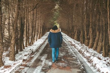 person walking on road covered snow