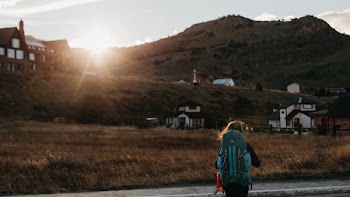 person walking on road staring at houses