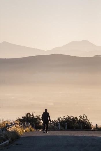 Person Walking on Road Viewing Mountain