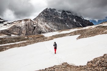 person walking on snow towards mountain