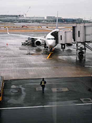 Person Walking Towards Airplane on Airport