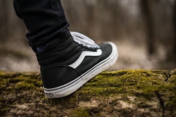 person wearing black and white Vans Sk8-Hi