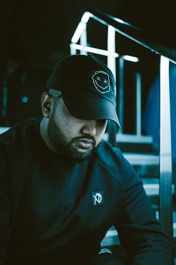 person wearing black cap beside staircase railings