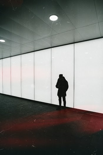 Person Wearing Black Jacket Standing Near Wall
