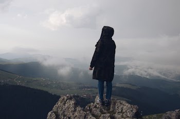 Person Wearing Black Jacket Standing on Mountain Edge