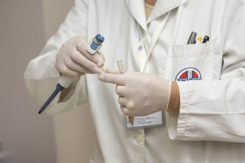 Person Wearing Black Laboratory Gown Holding Medical Apparatuses