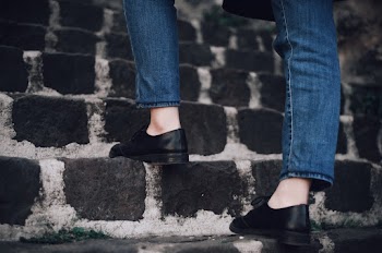Person Wearing Black Leather Shoes and Blue Denim Jeans Walking Upstairs