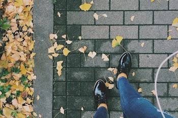 Person Wearing Black Patent Leather Dress Shoes on Gray Brick Pathway