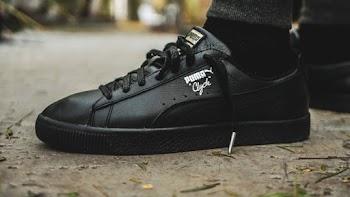 Person Wearing Black Puma Low-top Sneakers