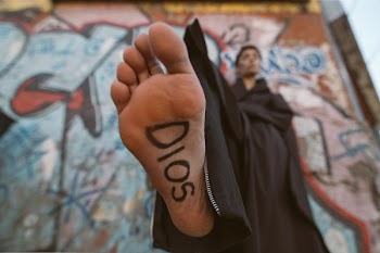 Person Wearing Black Robe With Sign on Foot