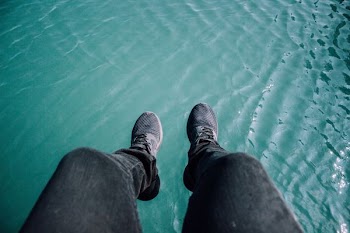 person wearing black sneakers and black pants