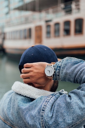 Person Wearing Blue Denim Jacket and Silver Round Analog Watch