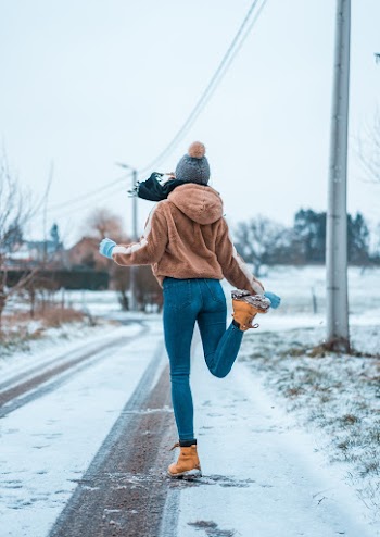 Person Wearing Blue Denim Jeans and Brown Hooded Jacket