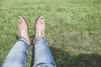 person wearing blue jeans and pair of white shoes