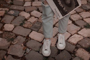 Person Wearing Blue Ripped Jeans and Pair of White Shoes