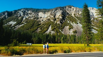 Person Wearing Blue Shirt Standing on Street Beside of Mountain