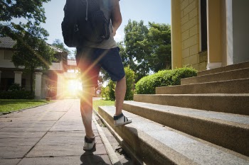 Person Wearing Blue Shorts Standing on Concrete Stair