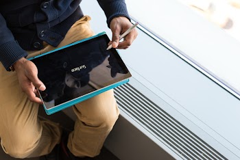 Person Wearing Brown Pants Holding Black Tablet Computer