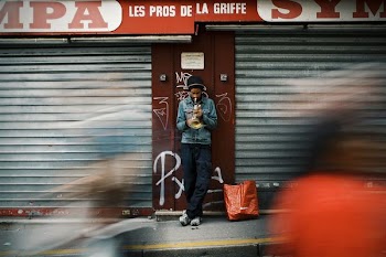 person wearing denim jacket standing near roller shutters