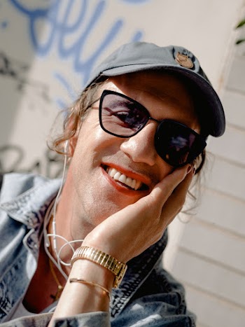 Person wearing eyeglasses and a Cap smiling 