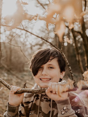 Person Wearing Gray and Black Pullover Hoodie Beside Trees