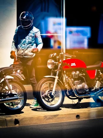 person wearing helmet standing near motorcycle