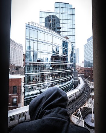 Person Wearing Hooded Top in Front of Running Train